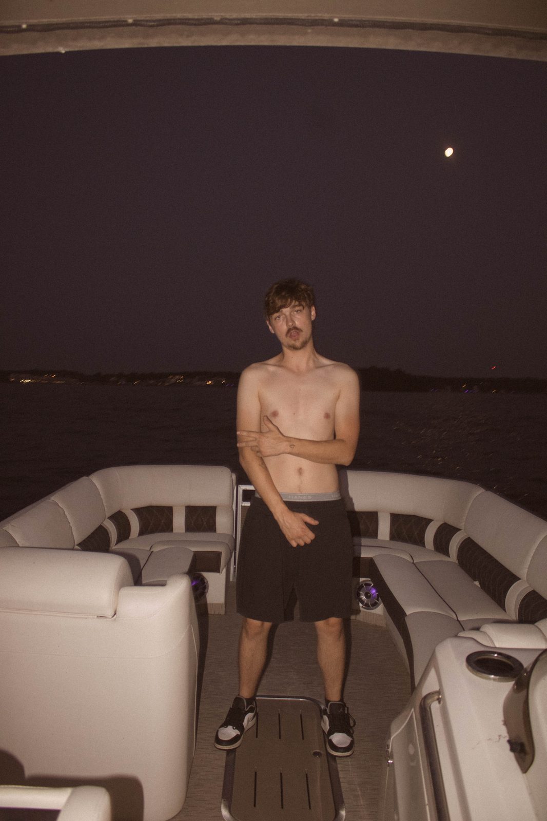 04Riley on the pontoon after dark, moon behind him