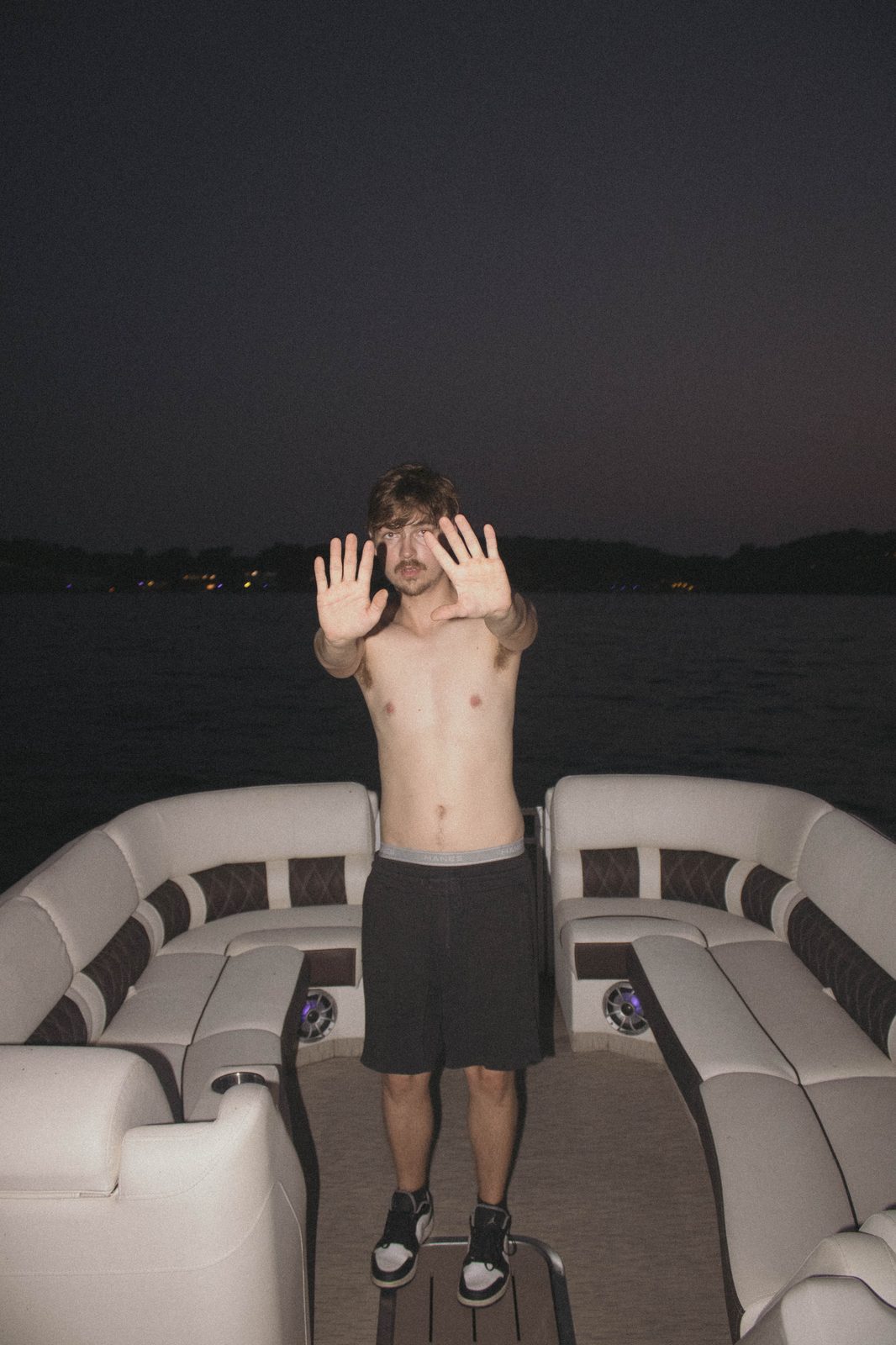 04Riley with both hands up to the flash on the pontoon